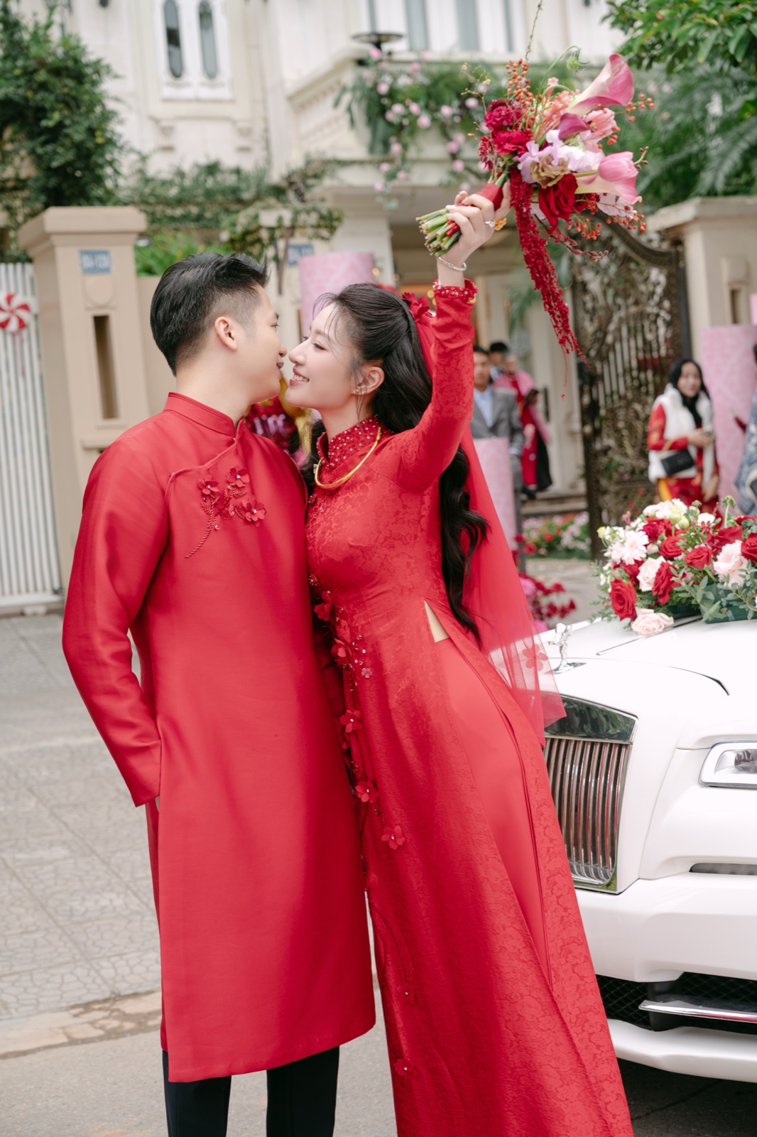 Chú rể hôn cô dâu bên xe hoa